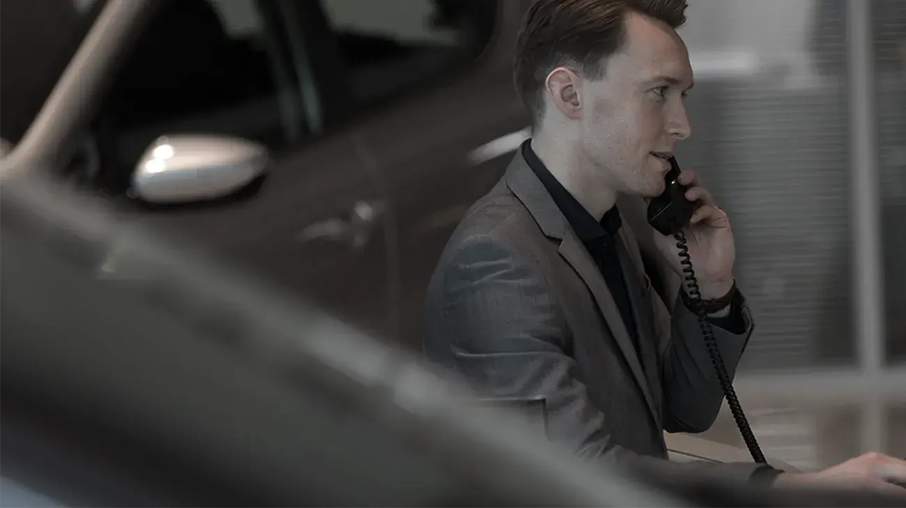 A man in a trendy office in a office attire making a work phone call