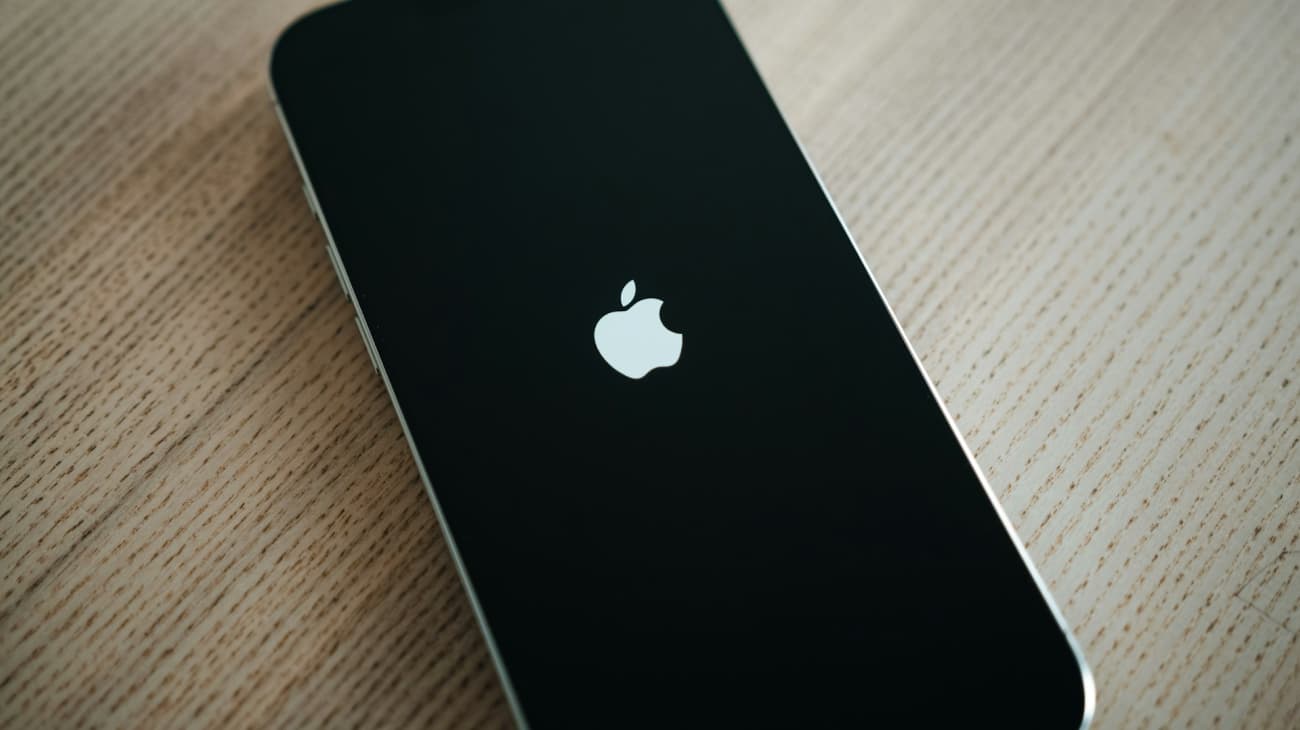 A simple iPhone loading the iOS on a wooden surface