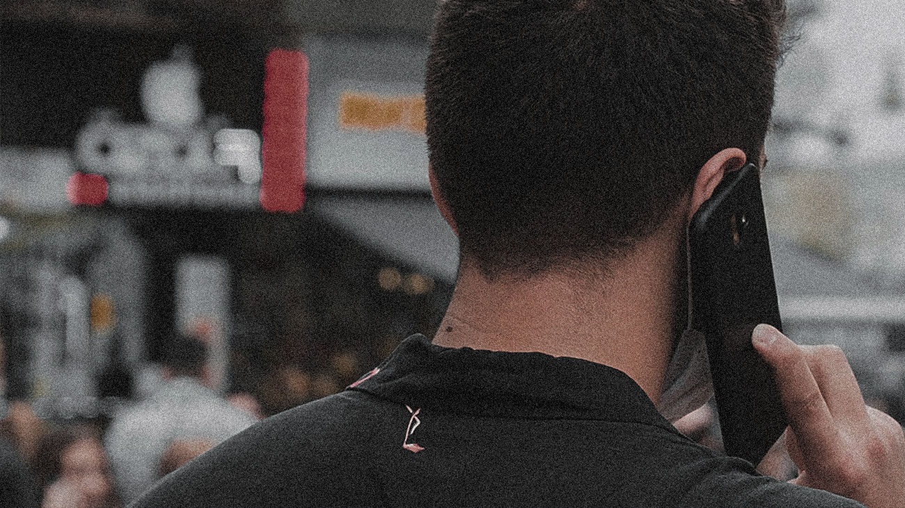 The back of the head of a young man talking on his mobile phone while out on the town